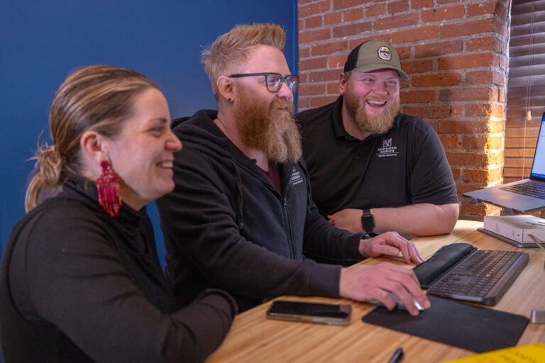 Erin Walker, Scott Rehnberg, and Sam Shoemaker from Improve and Grow working on a project together.