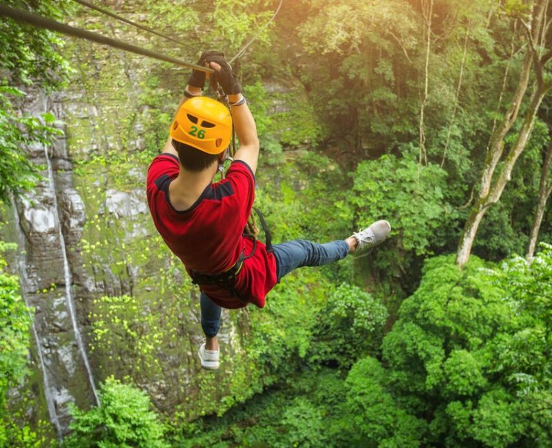 Happy guest ziplining at an outdoor attraction booked through digital marketing services